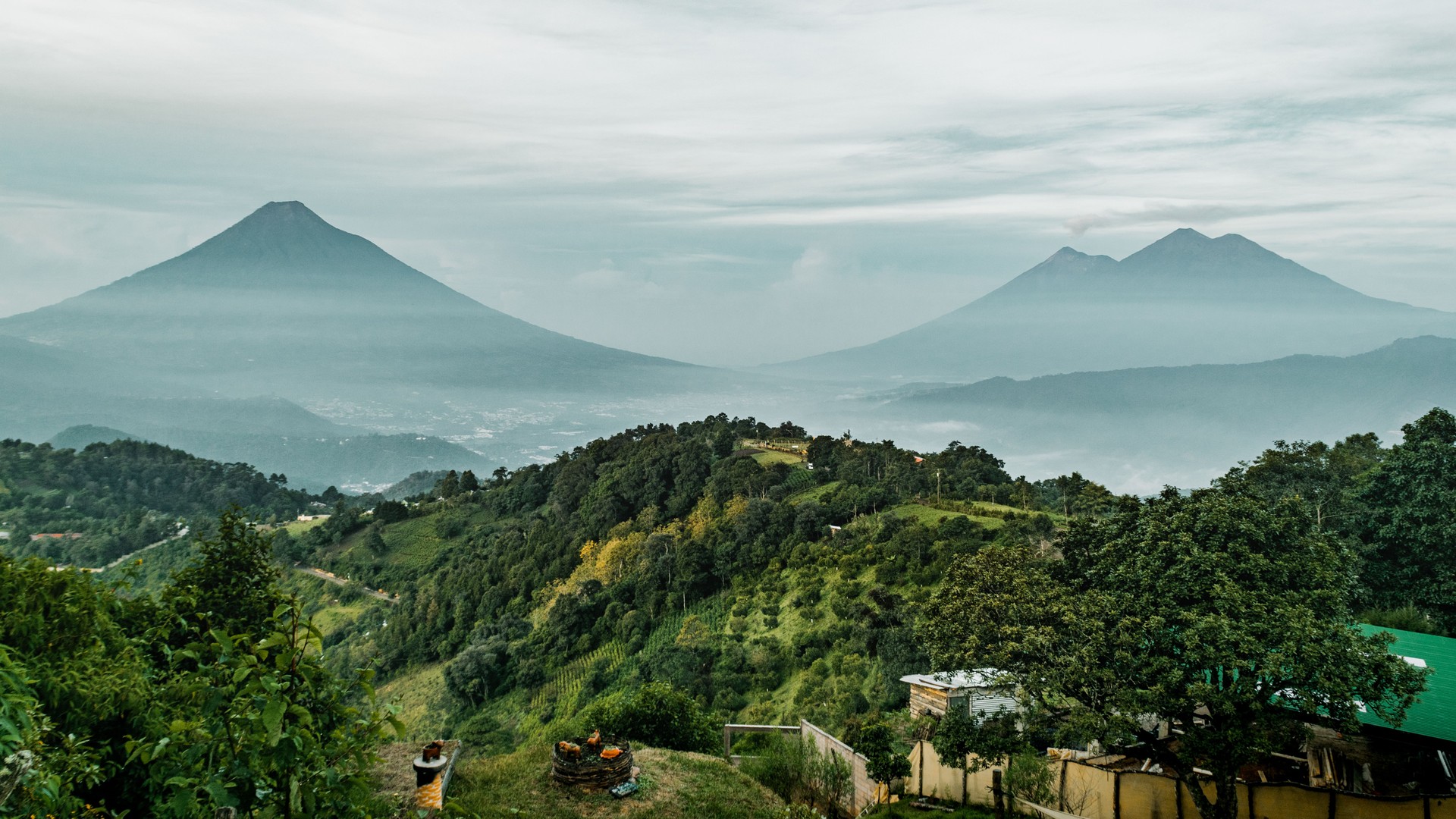 Green plants on hills and Volcan de Fuego mountains on the horizon in Antigua, Guatemala Green plants on hills and Volcan de Fuego mountains on the horizon in Antigua, Guatemala